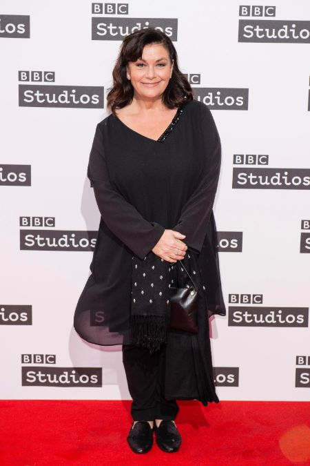 Dawn French in a black dress poses for a picture.